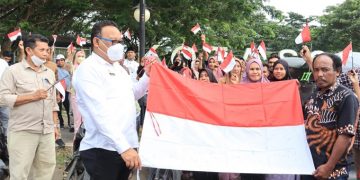 Sekda Malut, Samsuddin A. Kadir bersama Warga Sofifi Bagi-Bagi Bendera Merah Putih