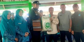 Bupati Bassam Kasuba Saat Menyerahkan Bantuan Beras pada Kades Talimau