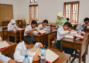 Para siswa SMP Loji Permai Kawasi sedang menikmati makan siang bergizi